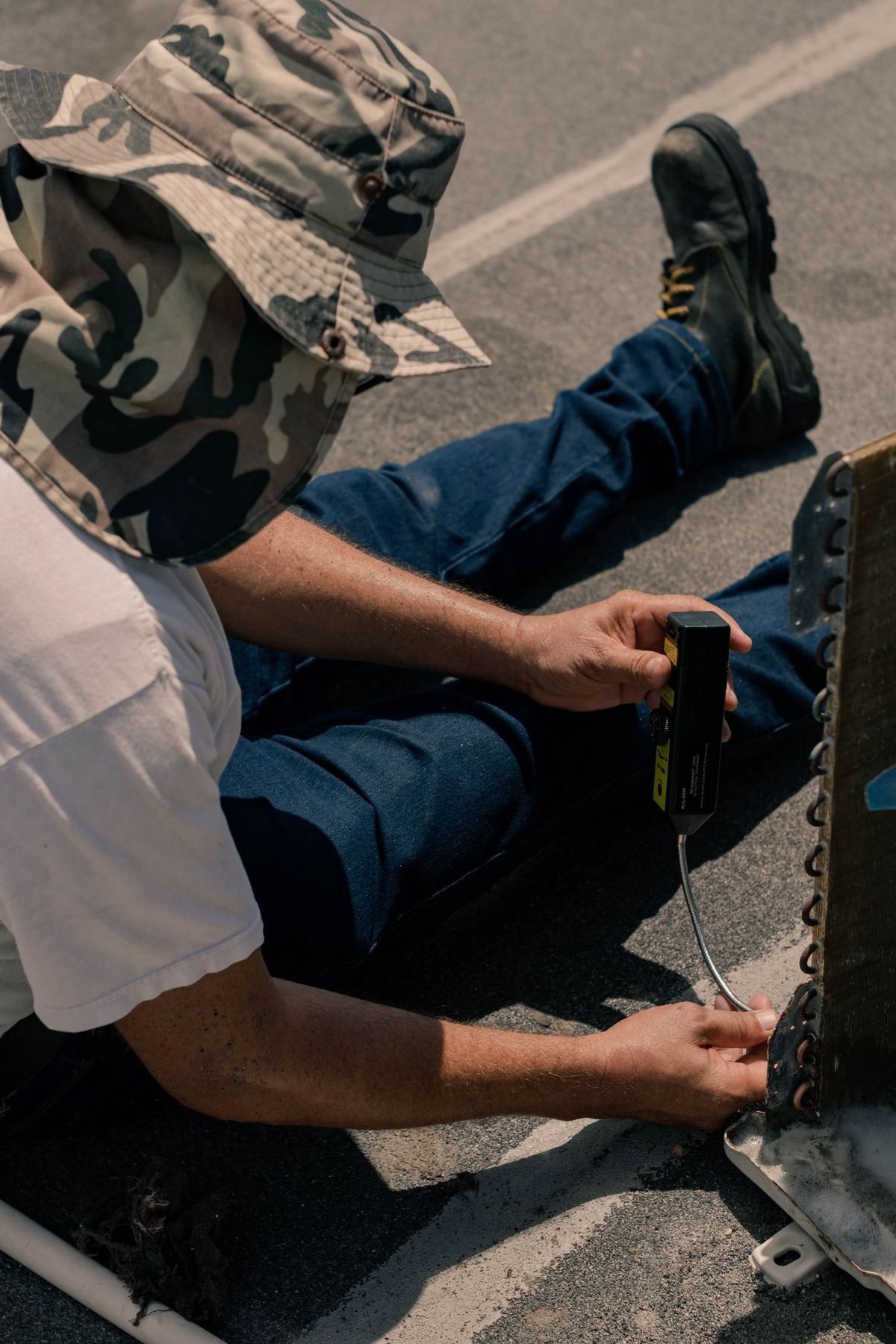 Manual laborer repairing an air conditioning unit outdoors