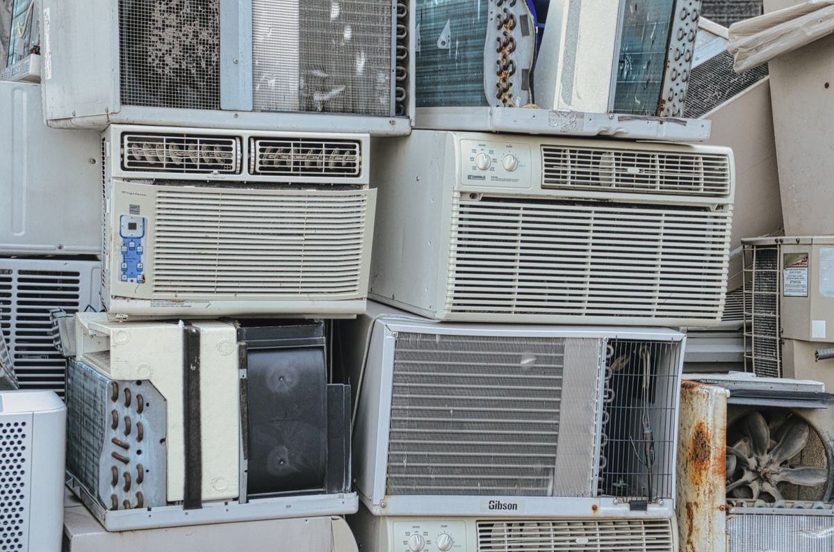 A pile of old window air conditioners set aside for recycling