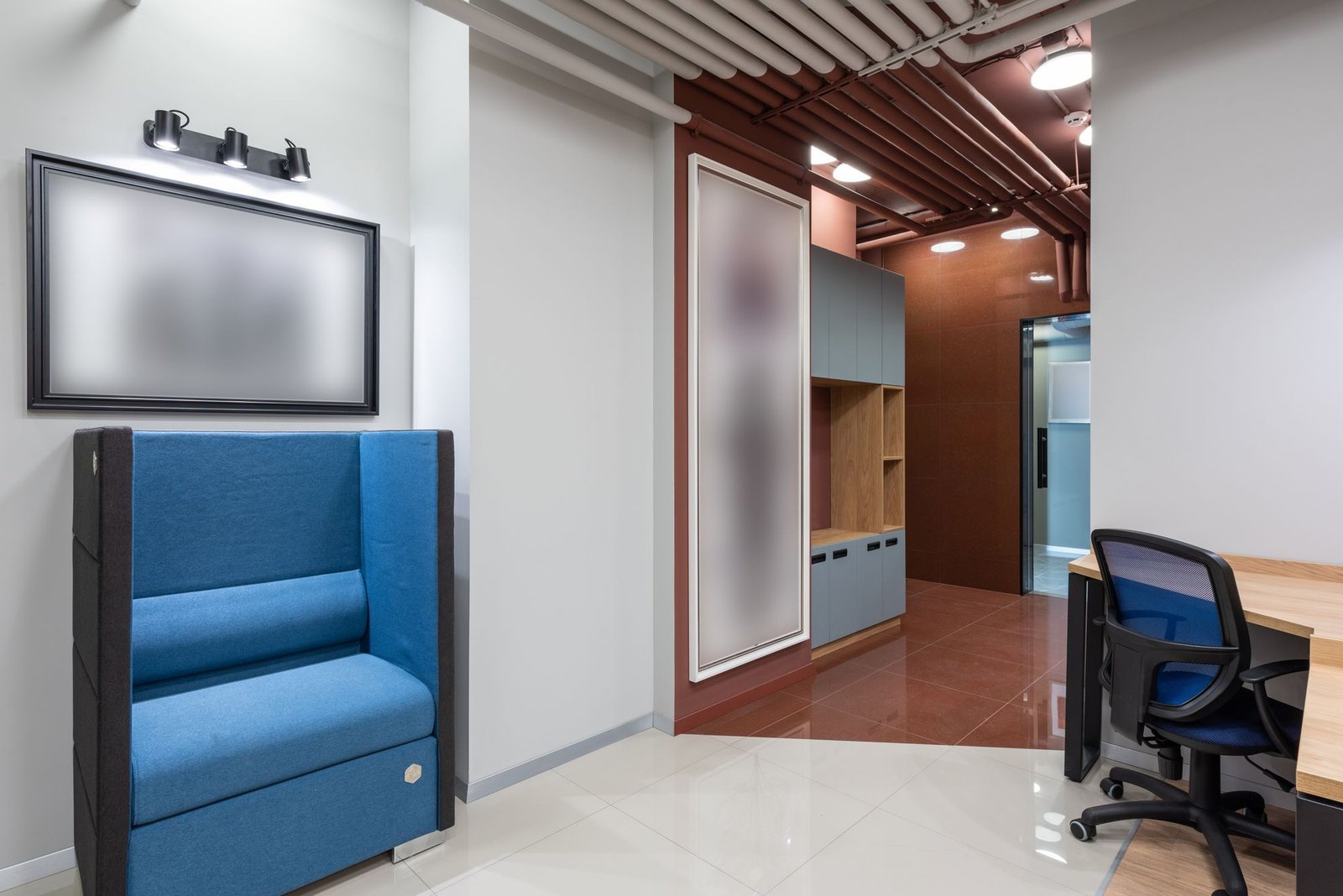 Blue sofa seating beneath a timber-slat acoustic ceiling and brown feature wall