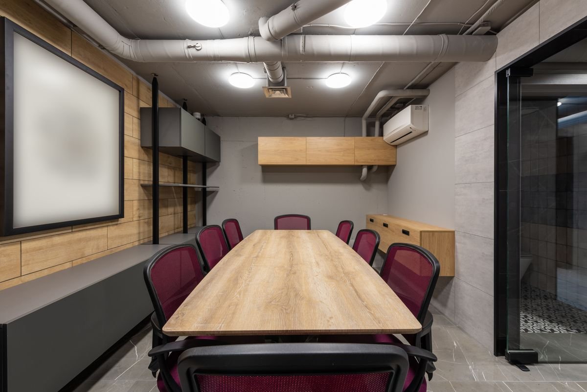 Boardroom with a timber table, burgundy chairs, and wood-panelled walls