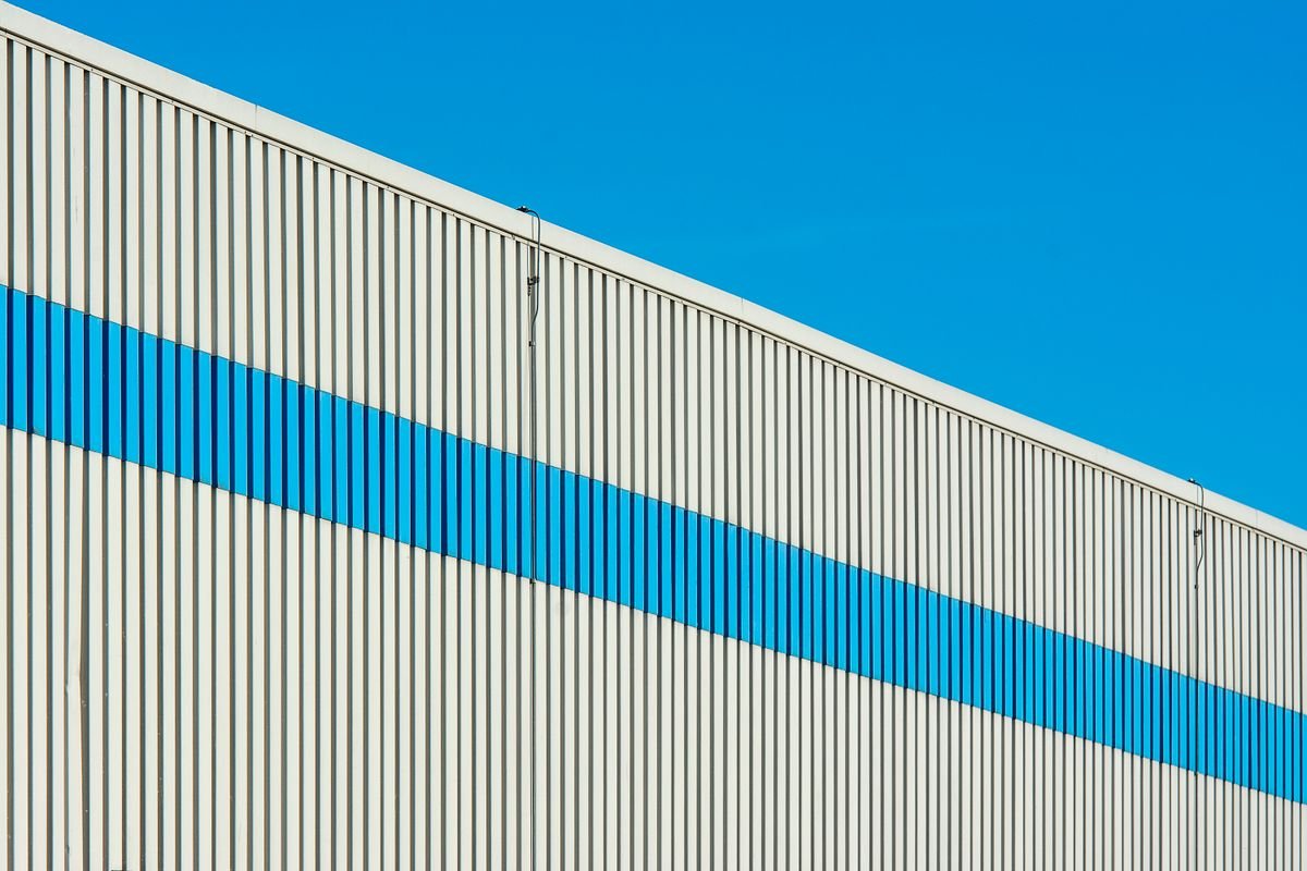 Industrial building facade with a distinctive blue stripe on a sunny day