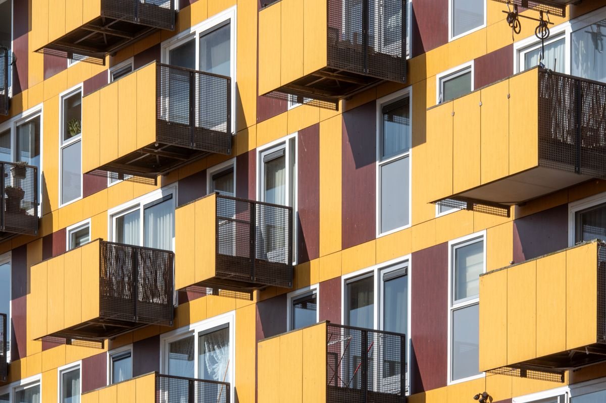 Geometric residential building facade with balconies and contrasting coloured cladding