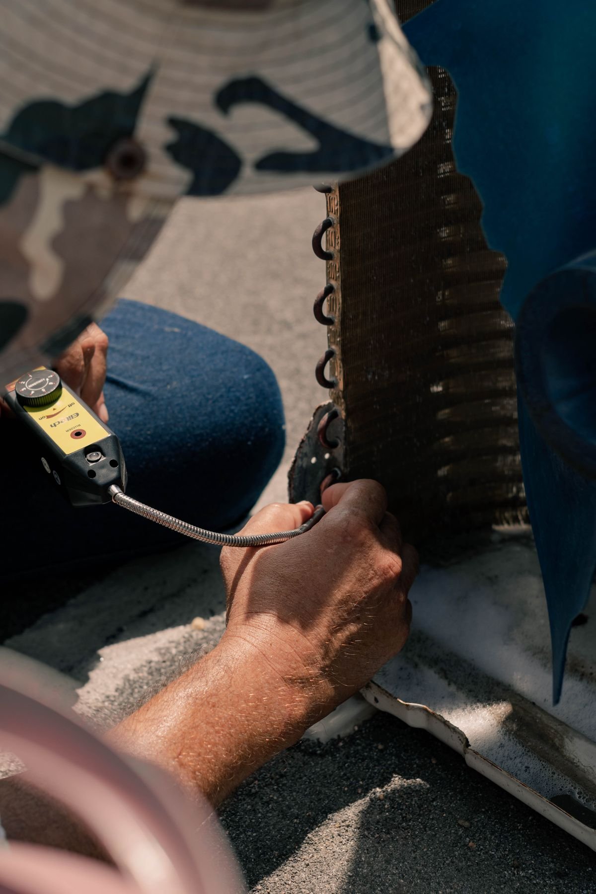 Technician repairing an air conditioner unit with tools