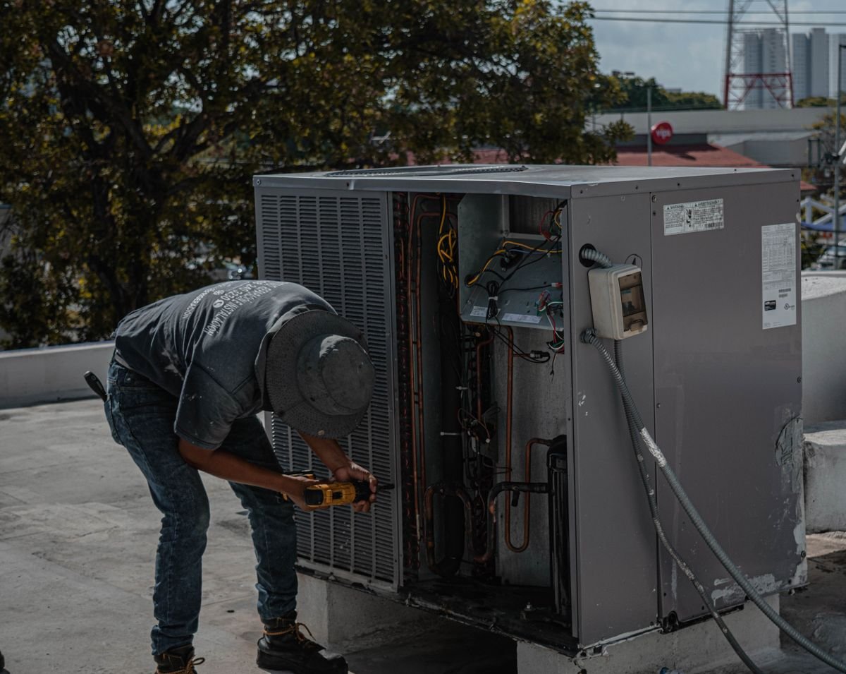 Technician installing an air conditioner unit outdoors