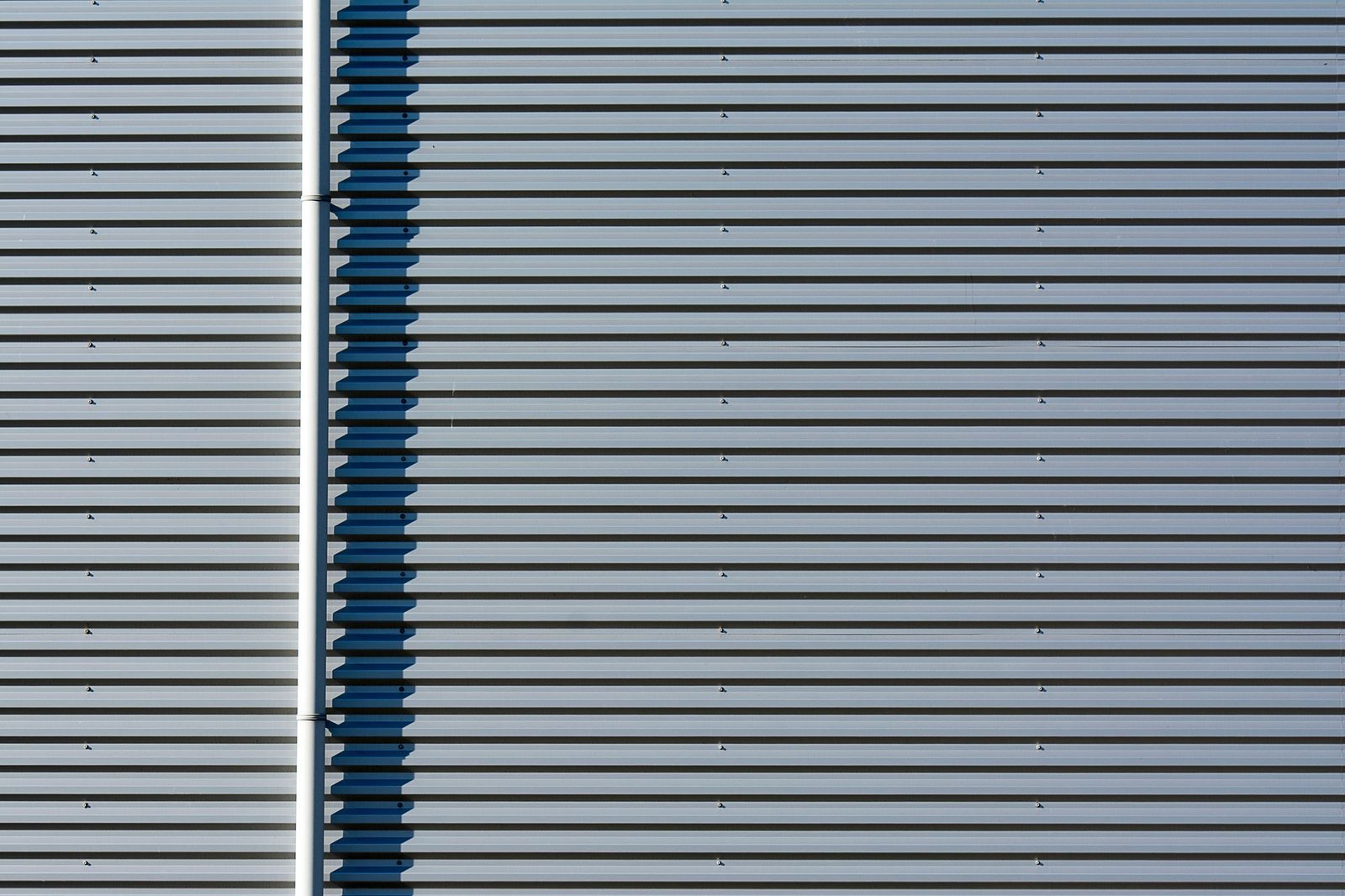 Close-up of an industrial metal facade with strong linear panel patterns