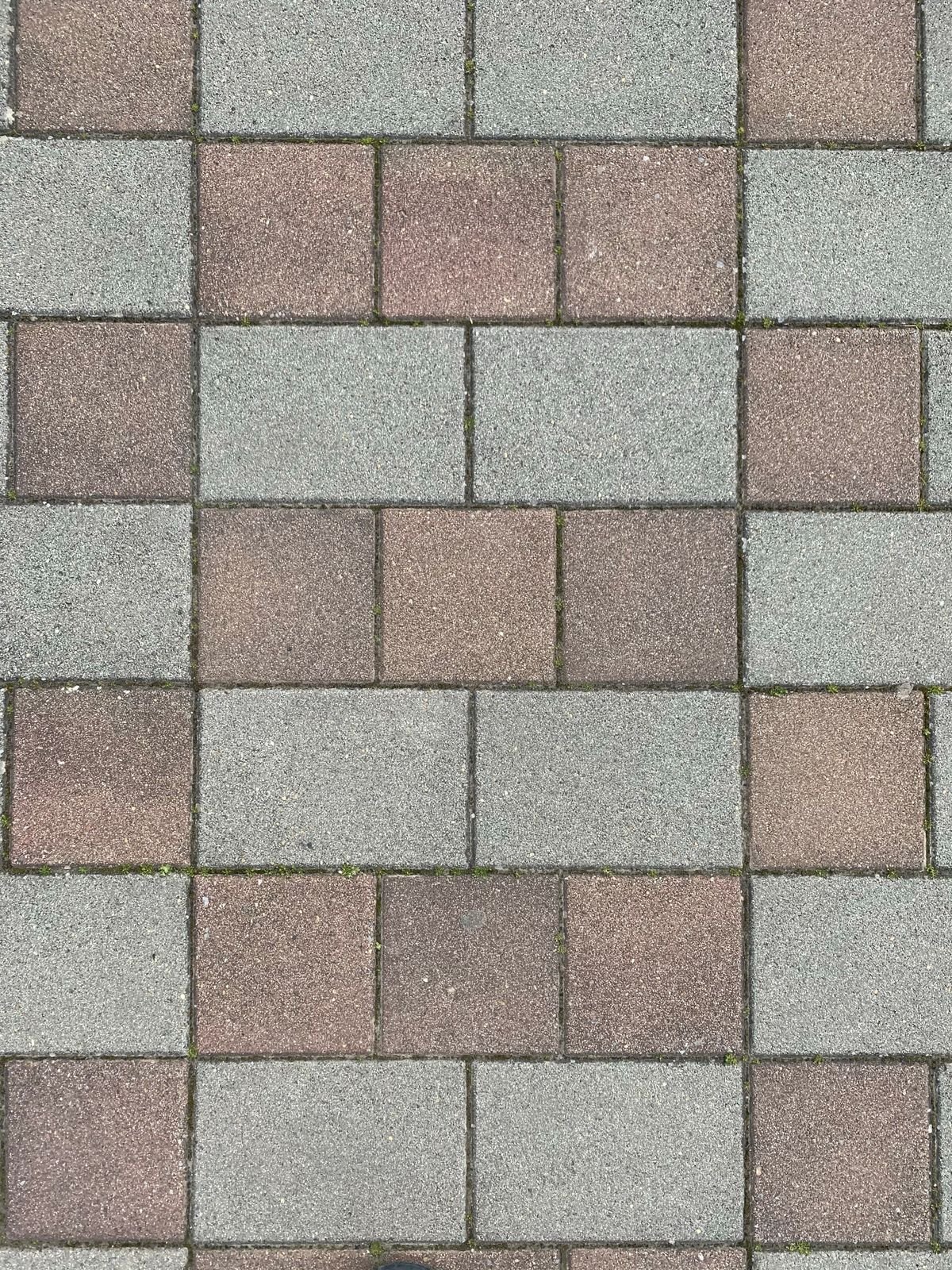 Brown and grey concrete pavers laid in a staggered running-bond pattern