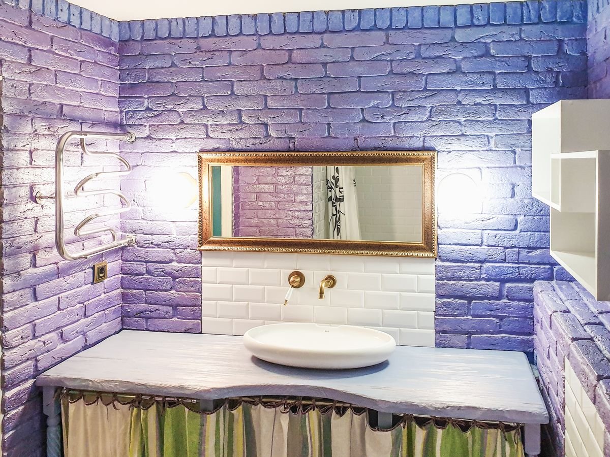 Bathroom with a purple brick-effect feature wall above a wooden vanity