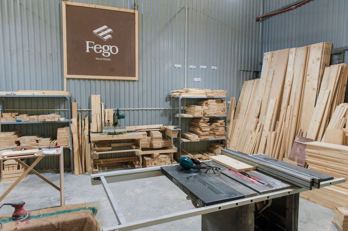 Interior of a woodworking workshop with table saw and lumber