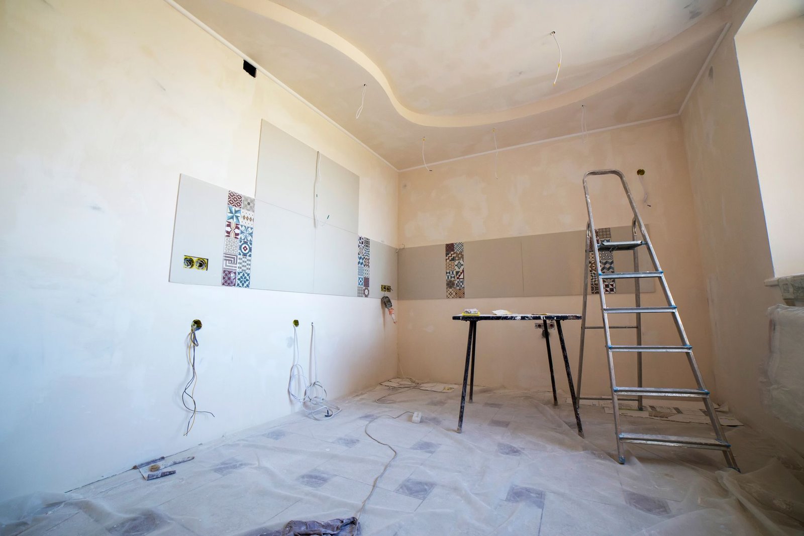 Room mid-renovation showing a freshly plastered ceiling with coving detail and a ladder