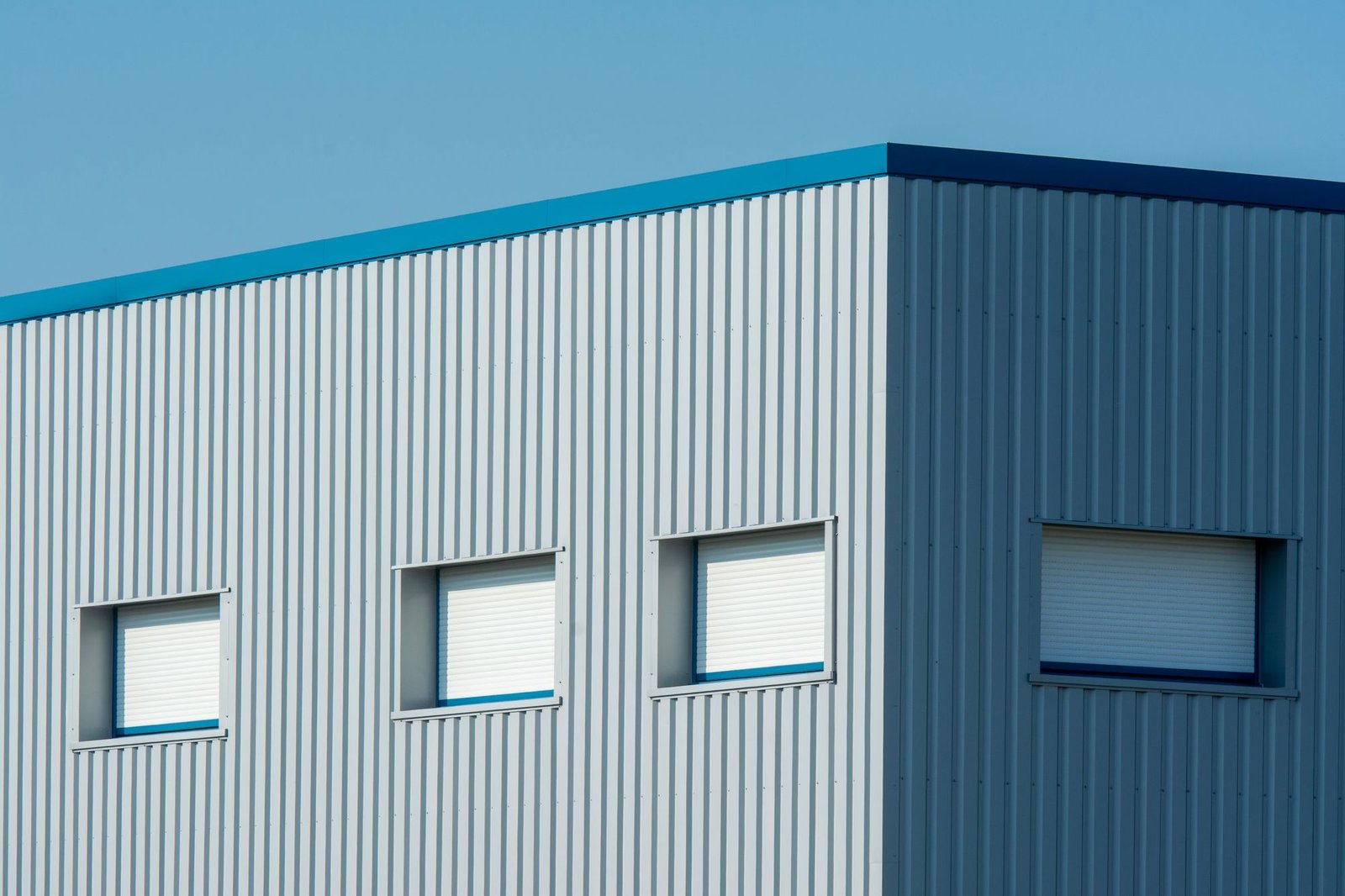 Sleek industrial building with a corrugated metal facade of sandwich panels and roller-blind windows