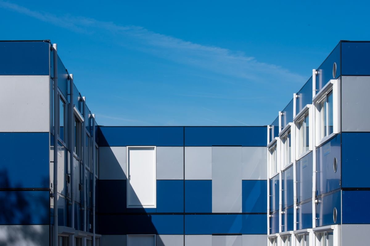Modular building with blue panels under a clear sky