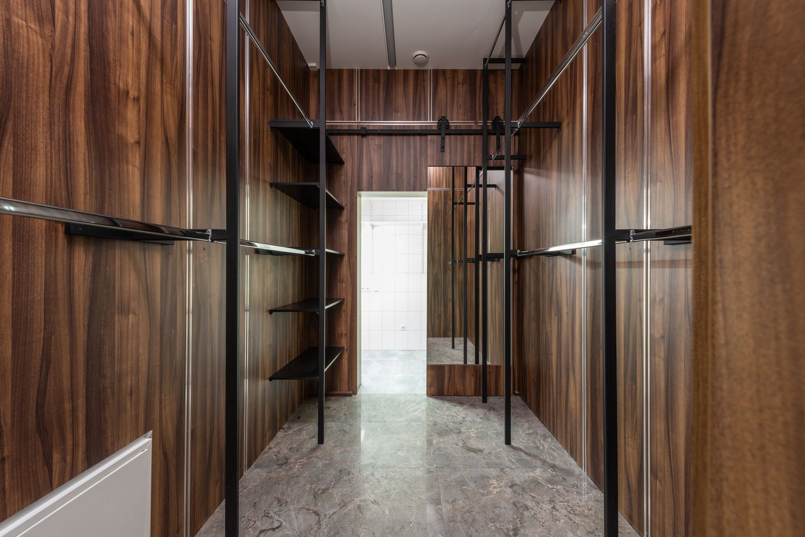 Spacious walk-in closet with wooden paneling and sleek storage solutions