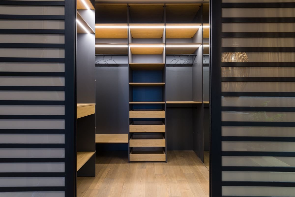 Spacious luxury walk-in closet with modern wooden shelving and stylish lighting