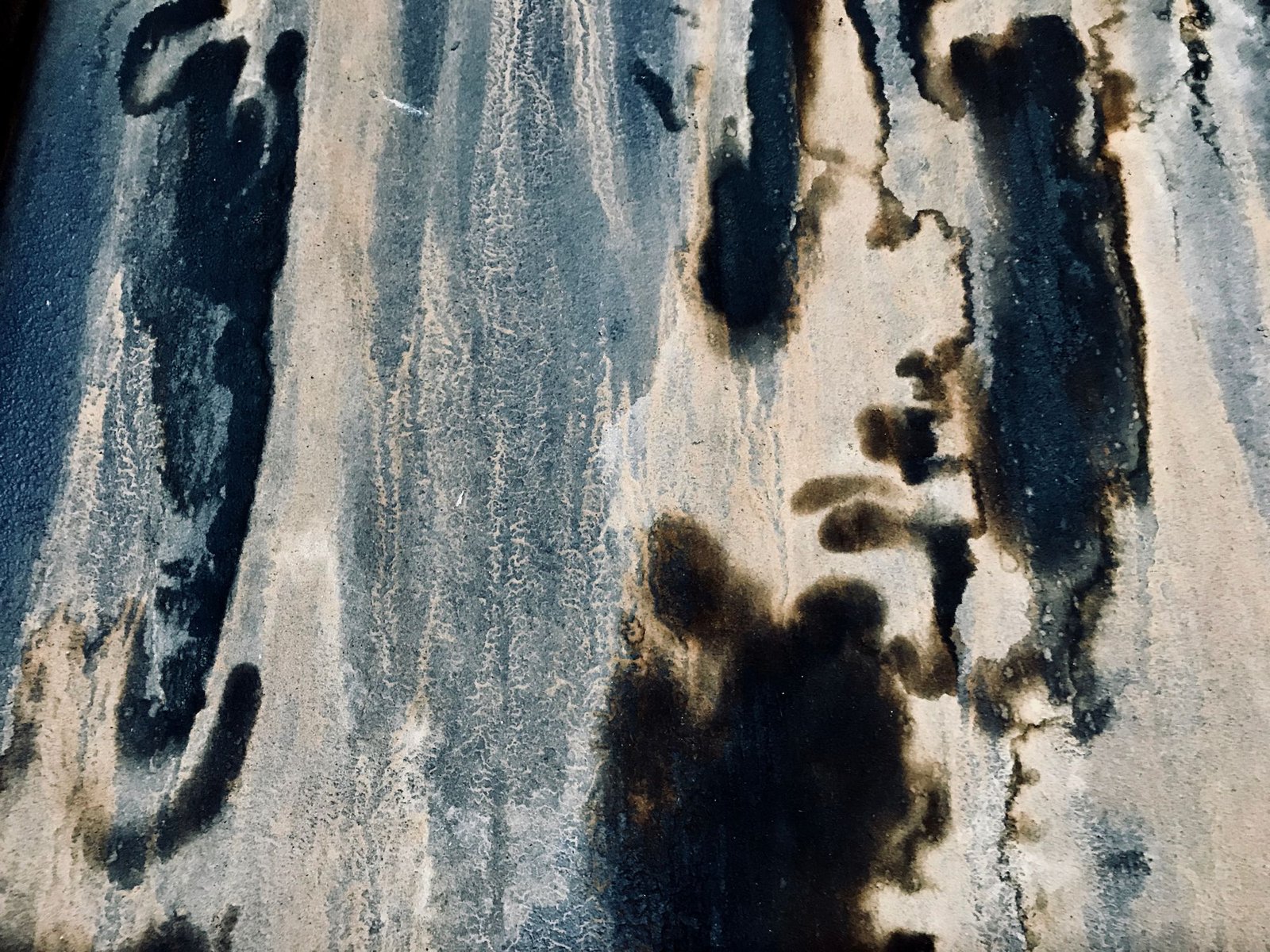 Dark mildew stains streaking down a damp weathered wall