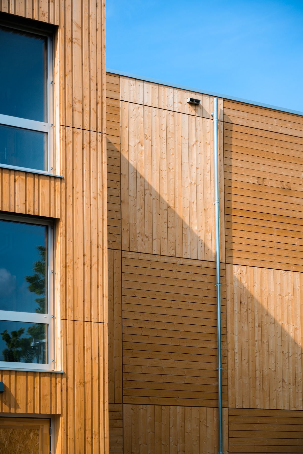 Modern wooden building exterior against a clear blue sky
