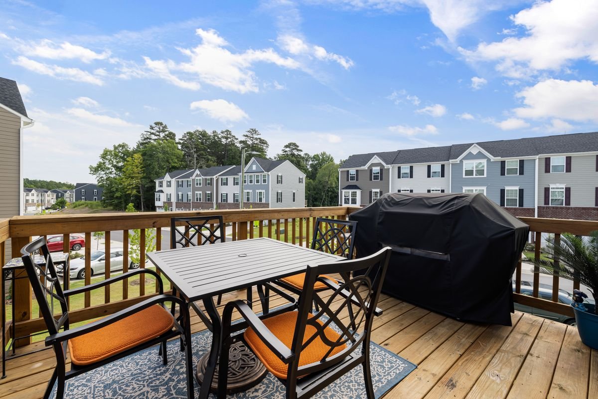 Wooden deck with table and chairs in a backyard setting