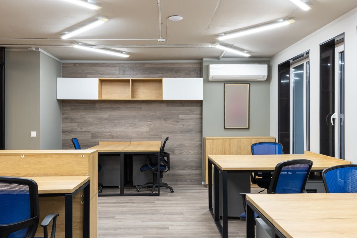 Open office with wooden worktops and a glazed partition along the wall