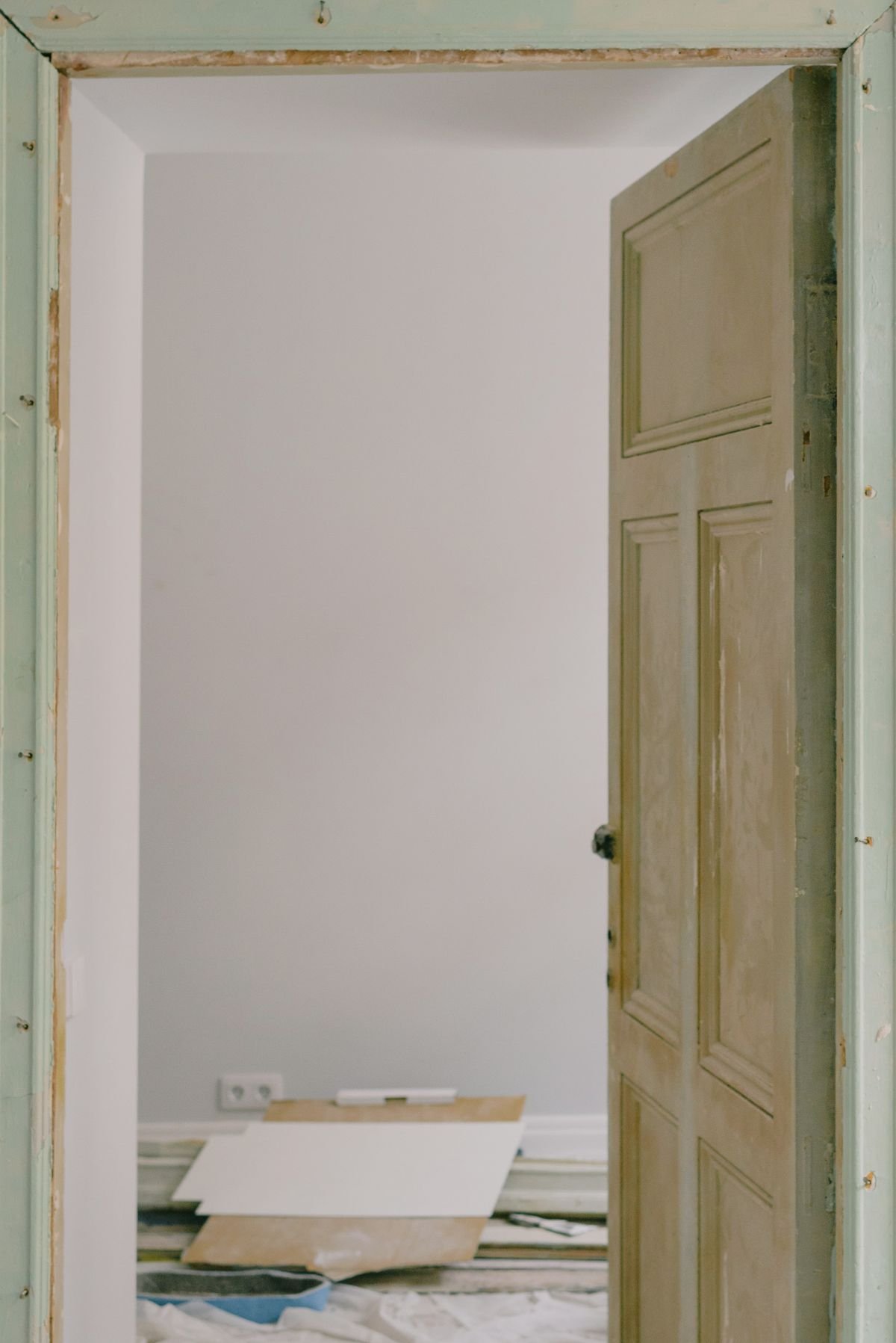 Wooden door in room with construction materials during renovation