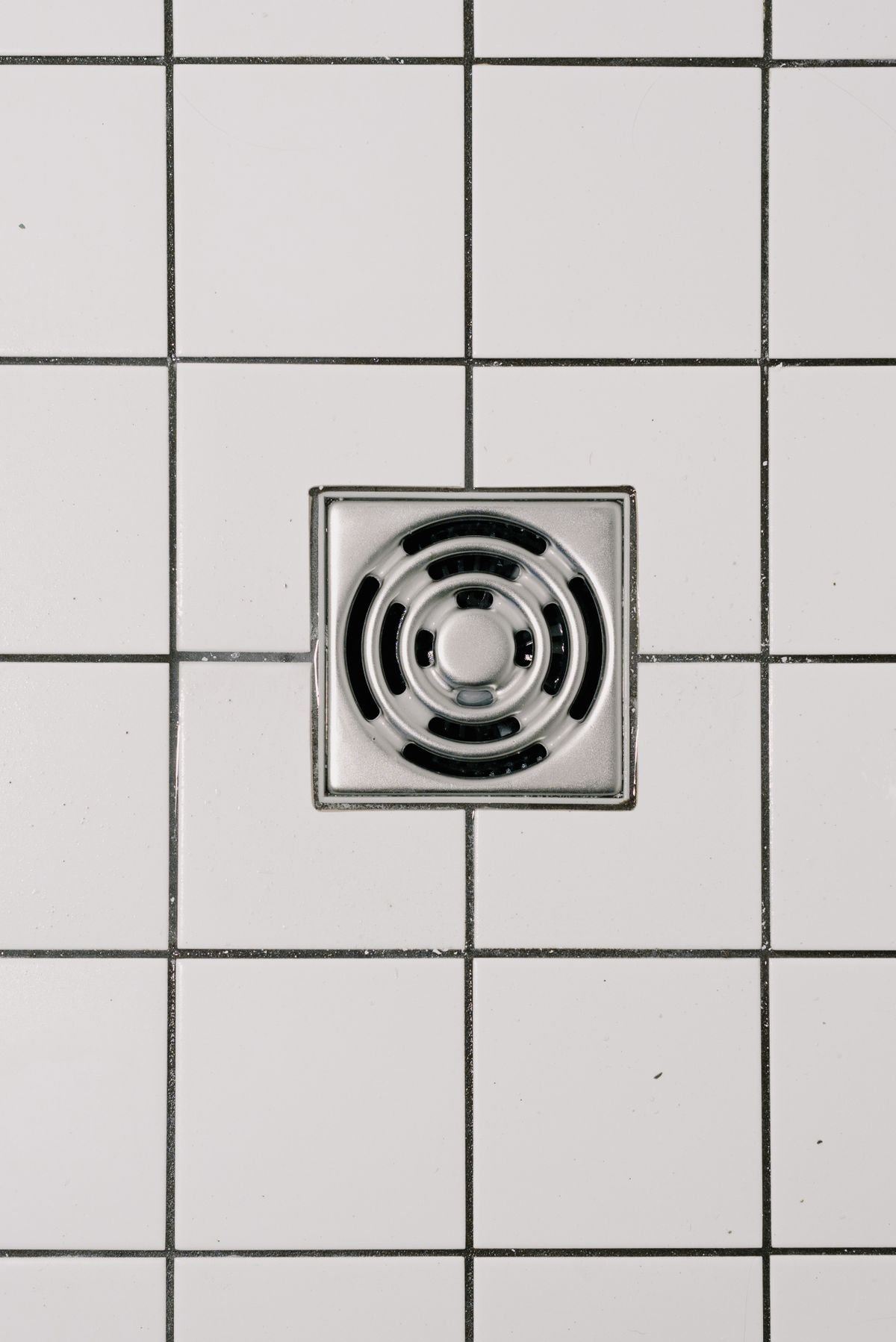 Stainless steel drain cover in a modern shower floor