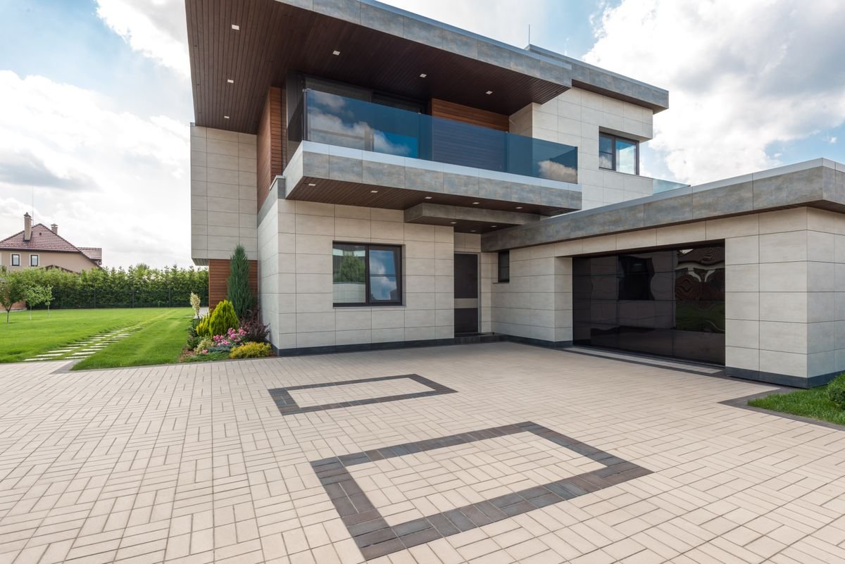 Modern house with a wide interlock paver driveway and geometric border
