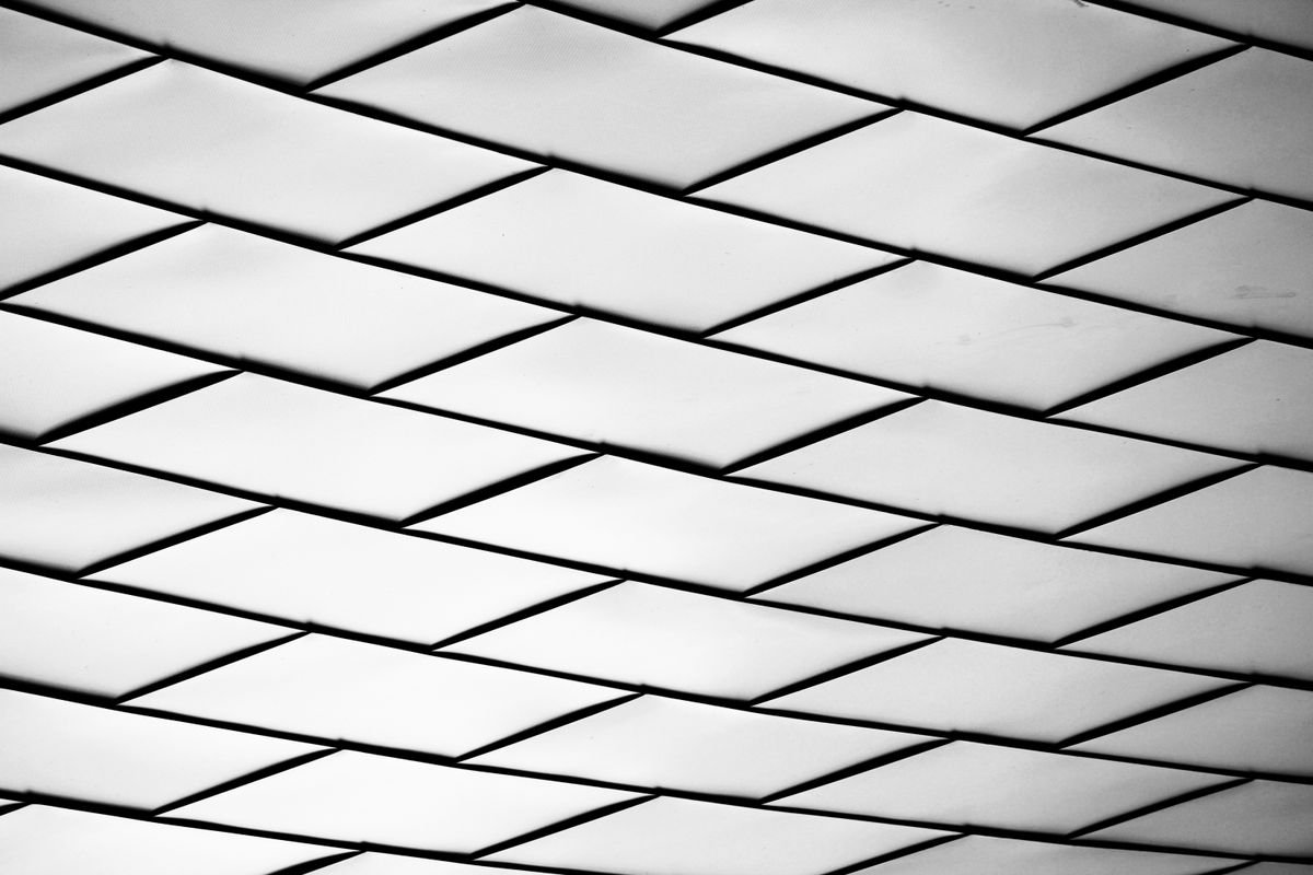 Black and white ceiling grid pattern of diamond-shaped panels