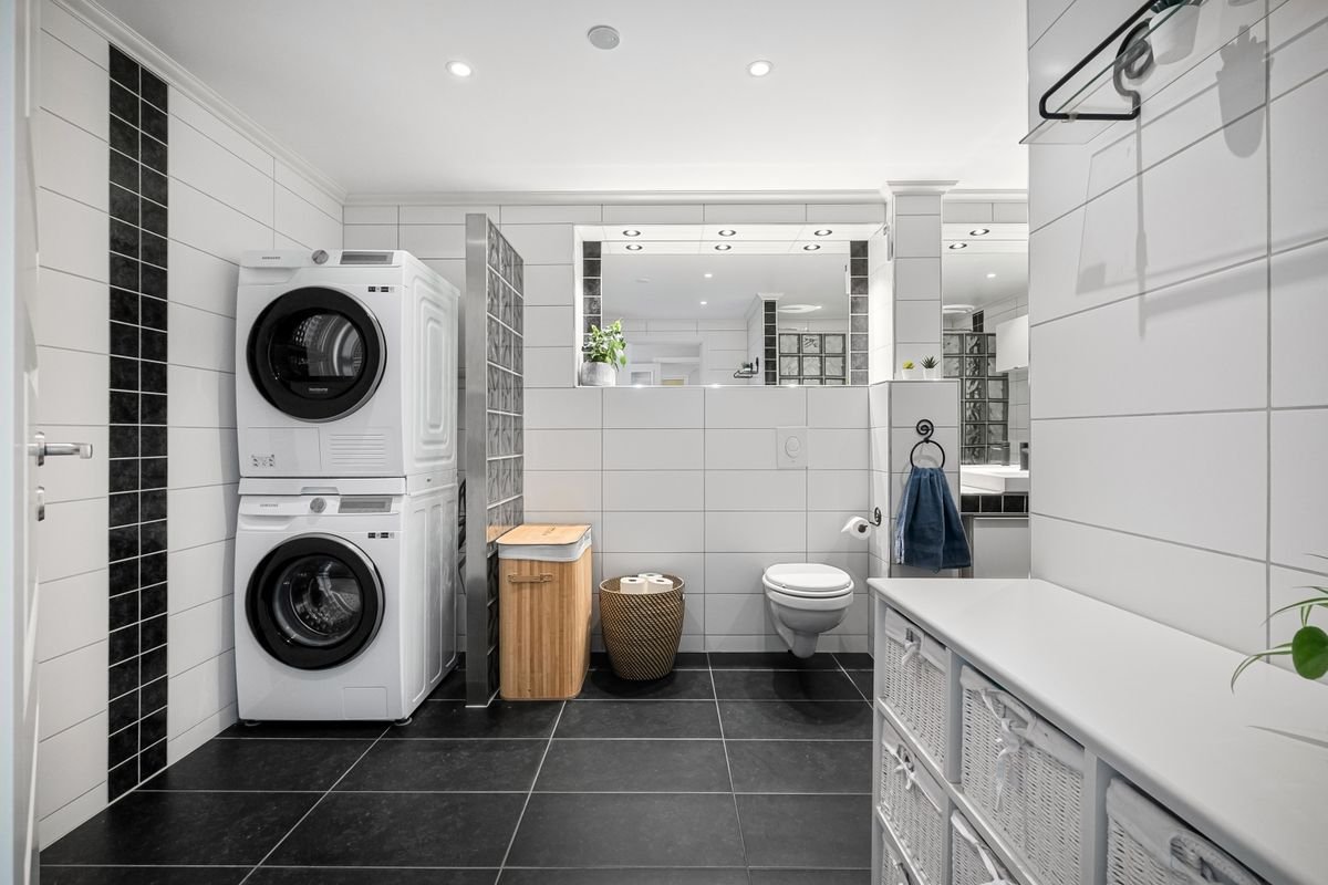 Stacked washing machine and dryer in a modern bathroom