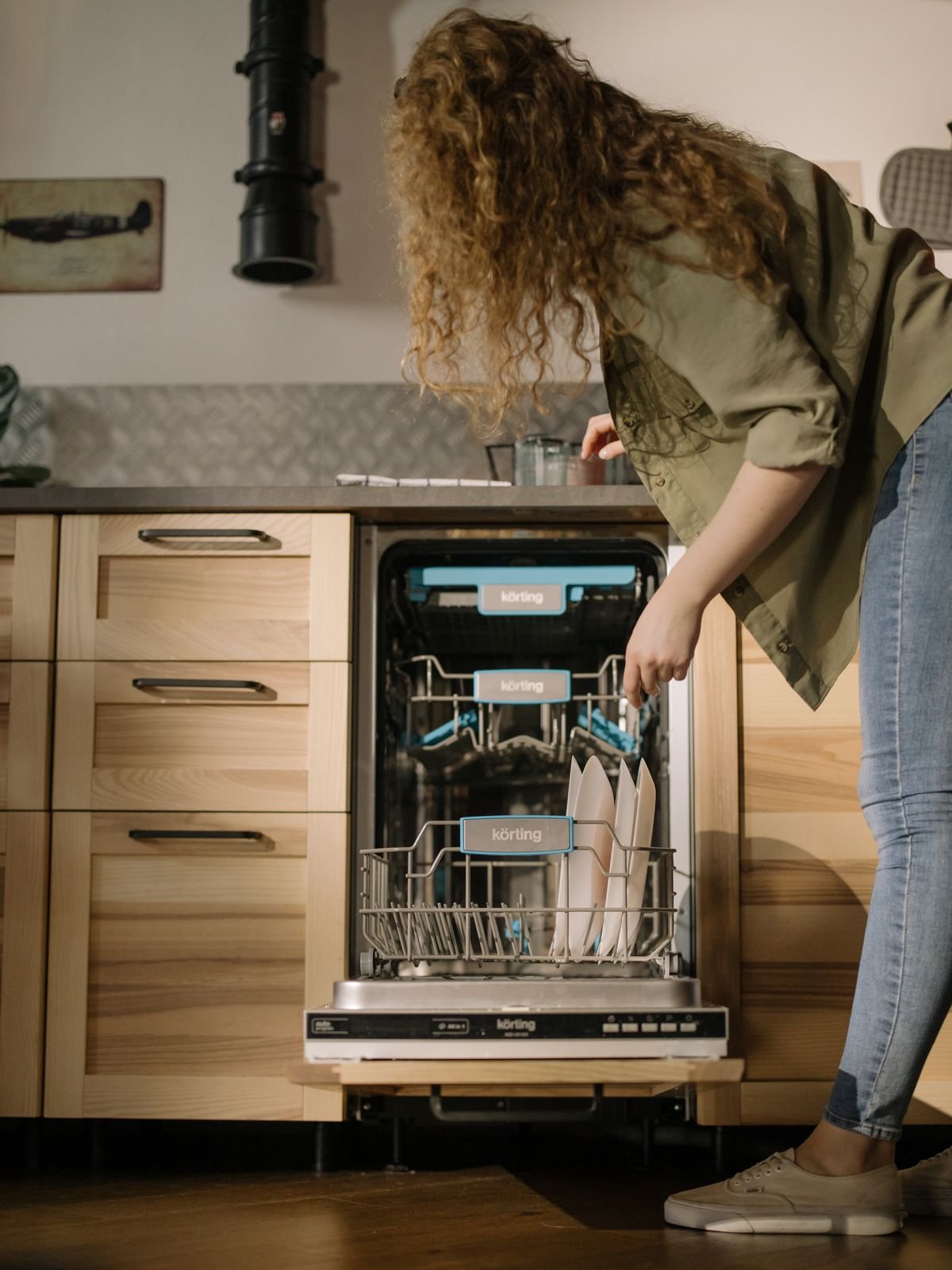 Woman loading dishes into a modern dishwasher