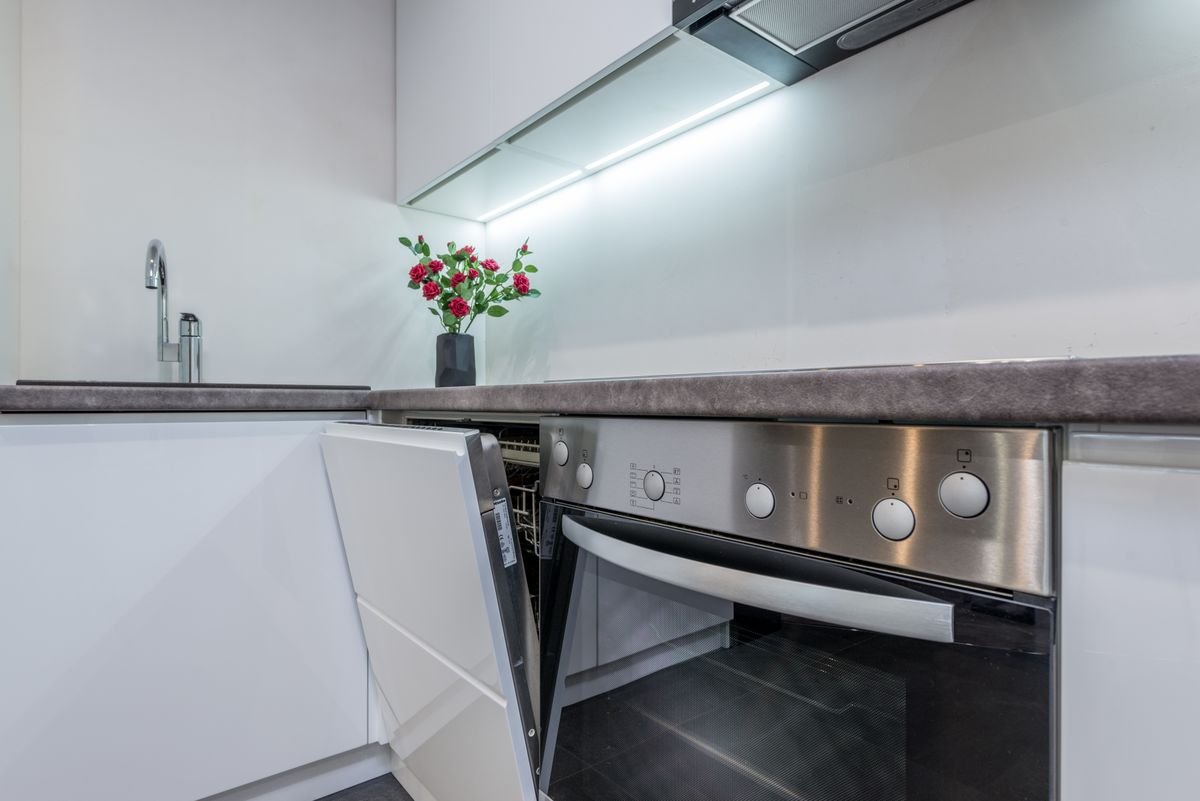 Sleek kitchen interior with an open integrated dishwasher