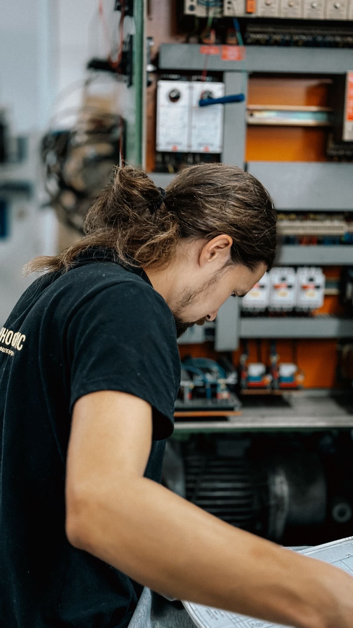 Technician inspecting an open electrical distribution panel