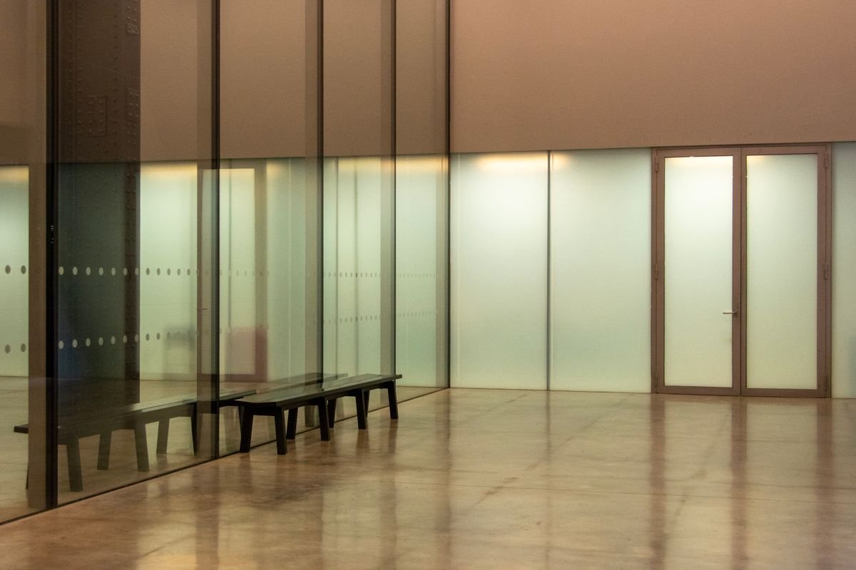 Showroom space with a polished warm-toned floor and frosted glass partitions