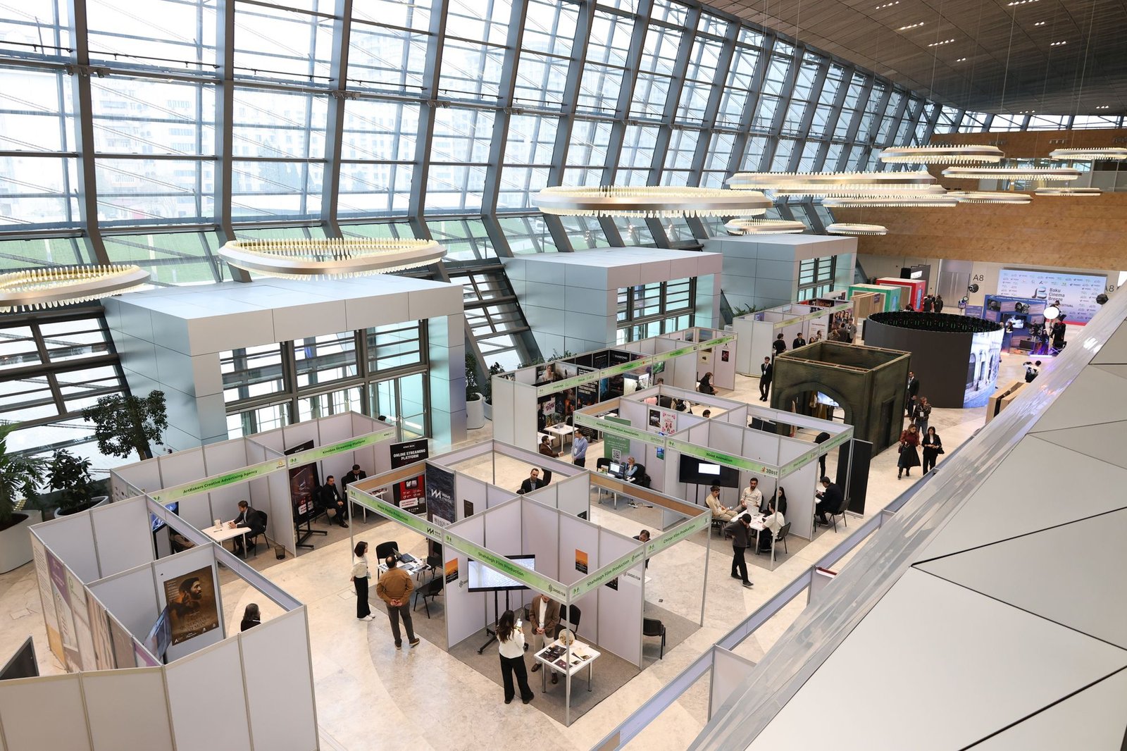 Modern trade show exhibition hall with multiple booths and attendees