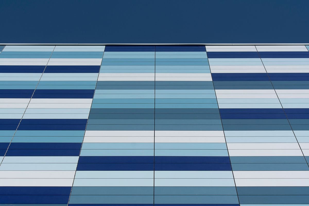 Close-up of a modern building facade with blue geometric patterns and stripes