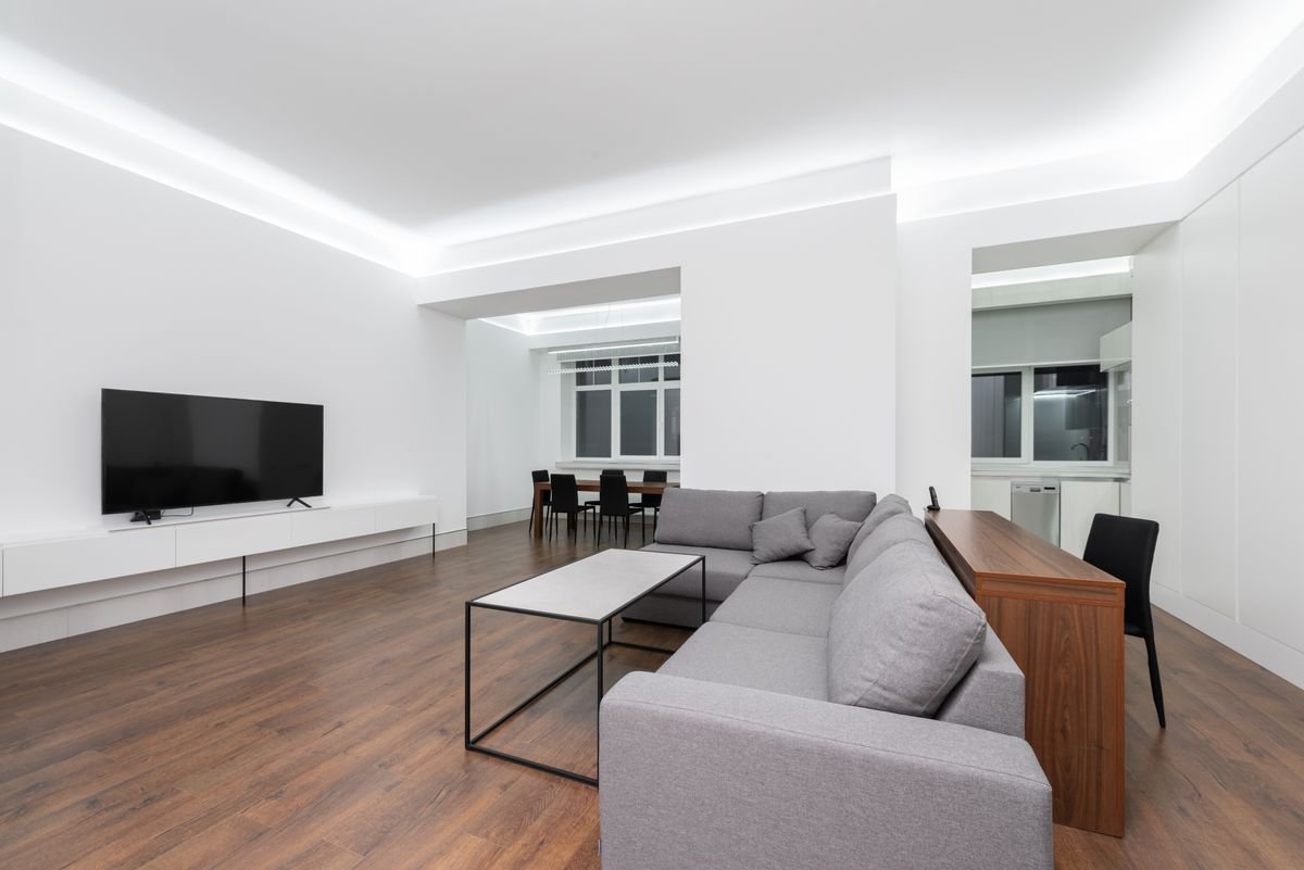 Living room with a cove-lit gypsum board ceiling and recessed lighting