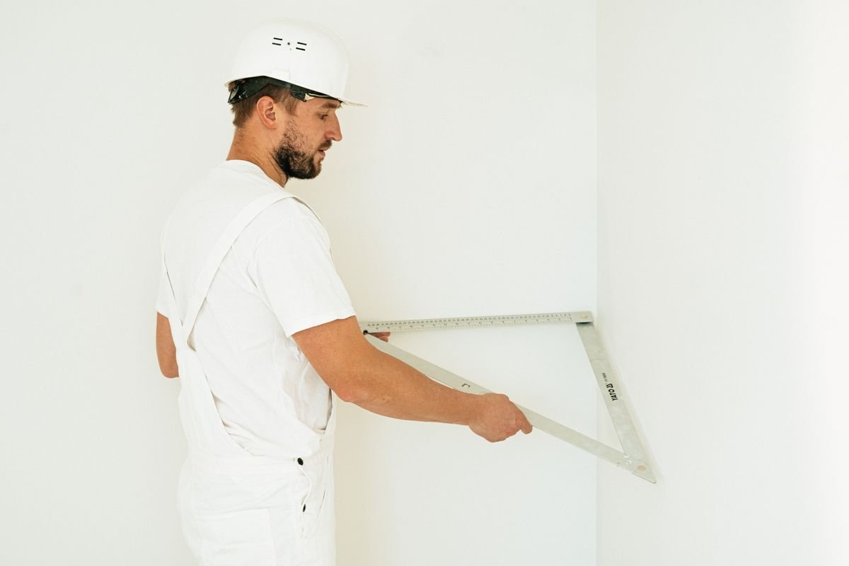 Technician checking a wall with a large set square