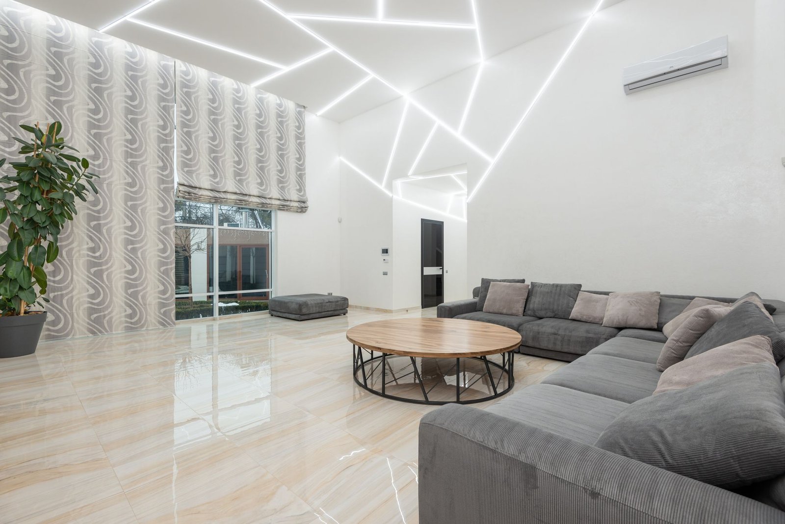 Double-height living room with an angular gypsum ceiling outlined in white LED light lines