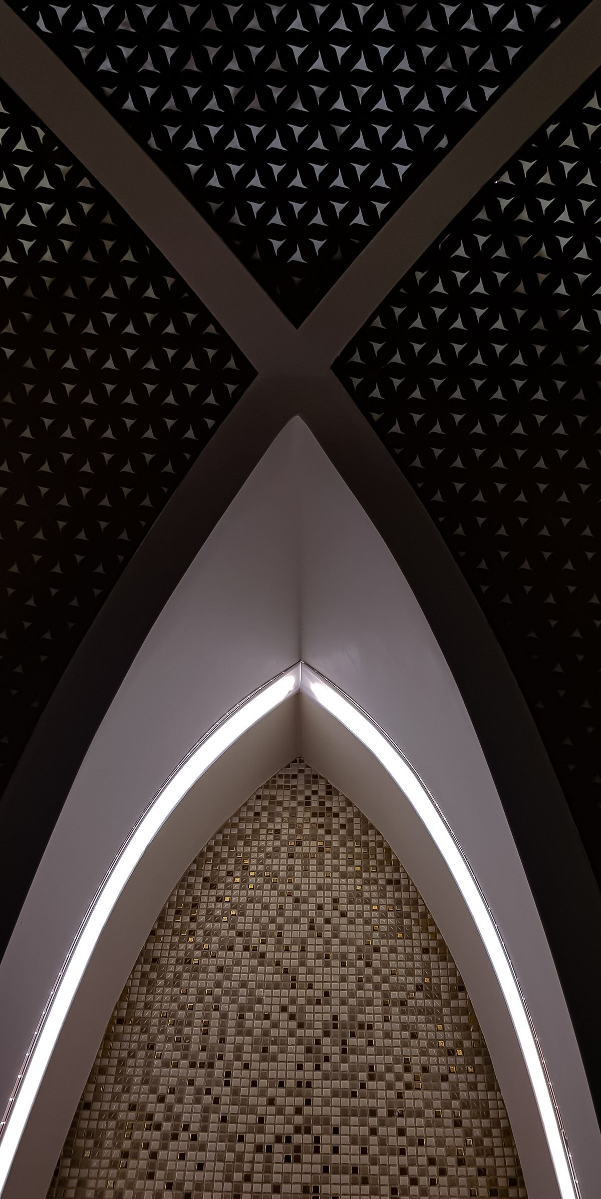 Dark patterned ceiling with an X-shaped cove and a curved LED light strip