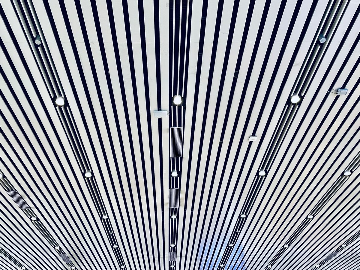 White linear baffle ceiling with embedded spotlights