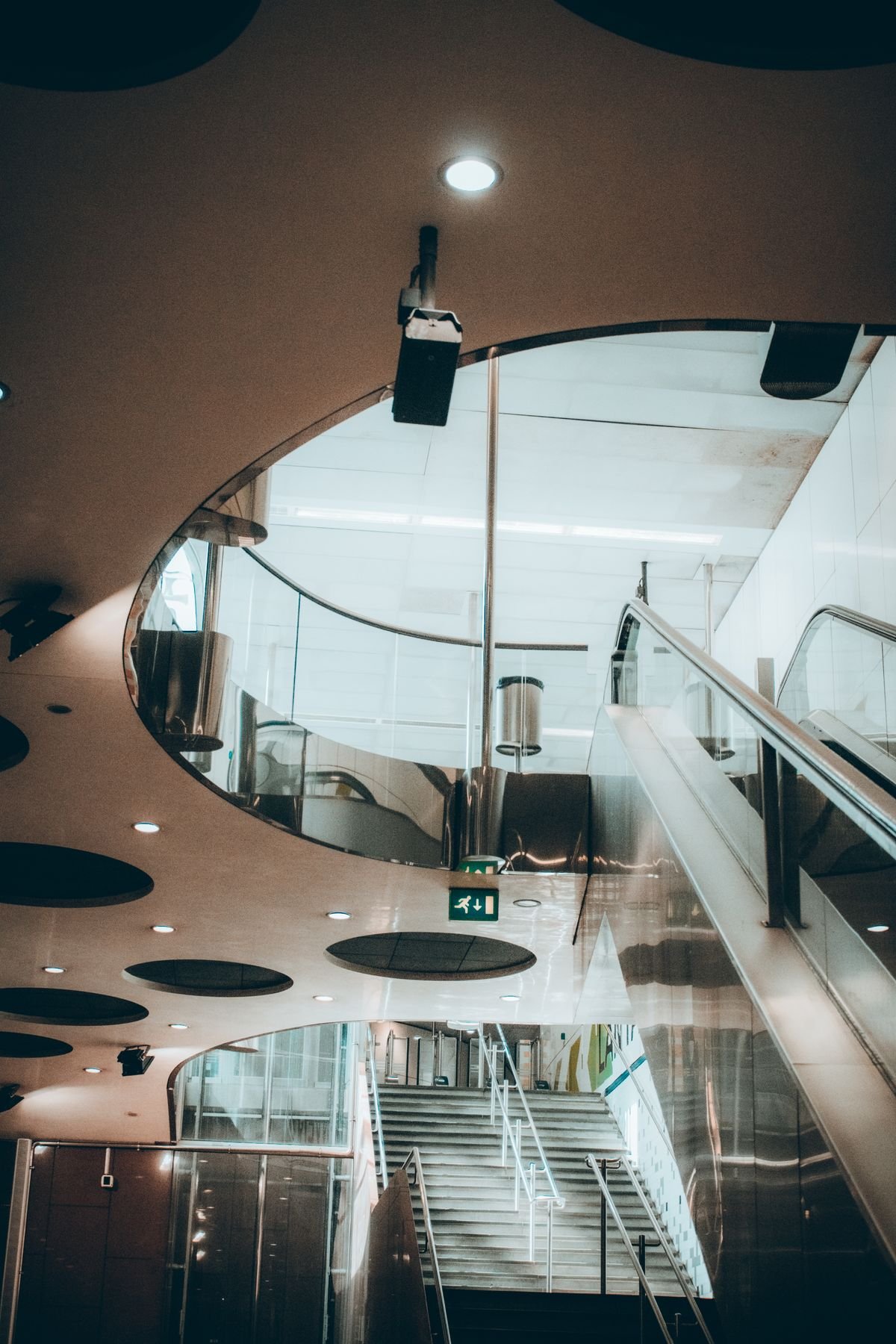 Curved white ceiling with round recessed openings in a modern building interior