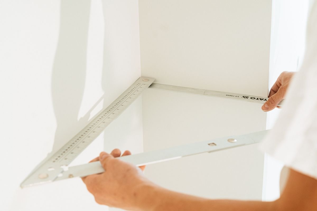 Technician checking a wall corner with a large set square