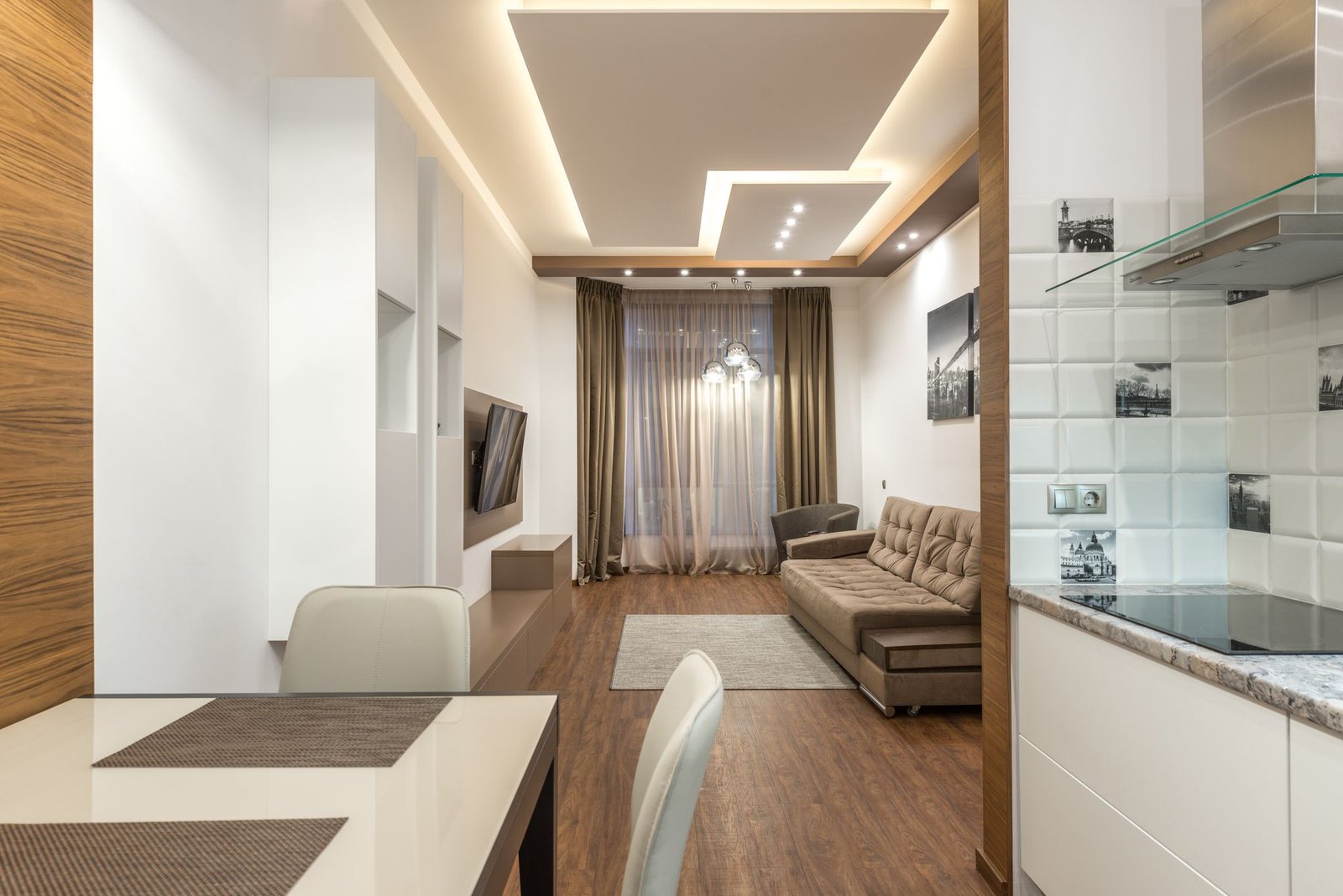 Open-plan living and kitchen area with a stepped gypsum false ceiling and recessed lighting