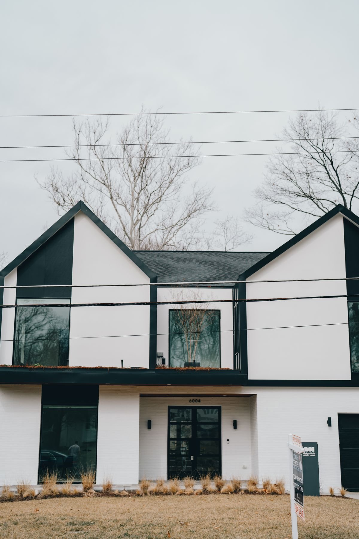 Contemporary residential building with a sleek black and white exterior and large windows