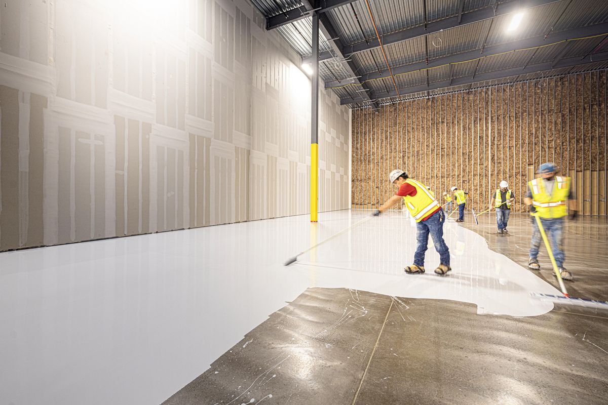 Construction workers laying a fresh concrete floor