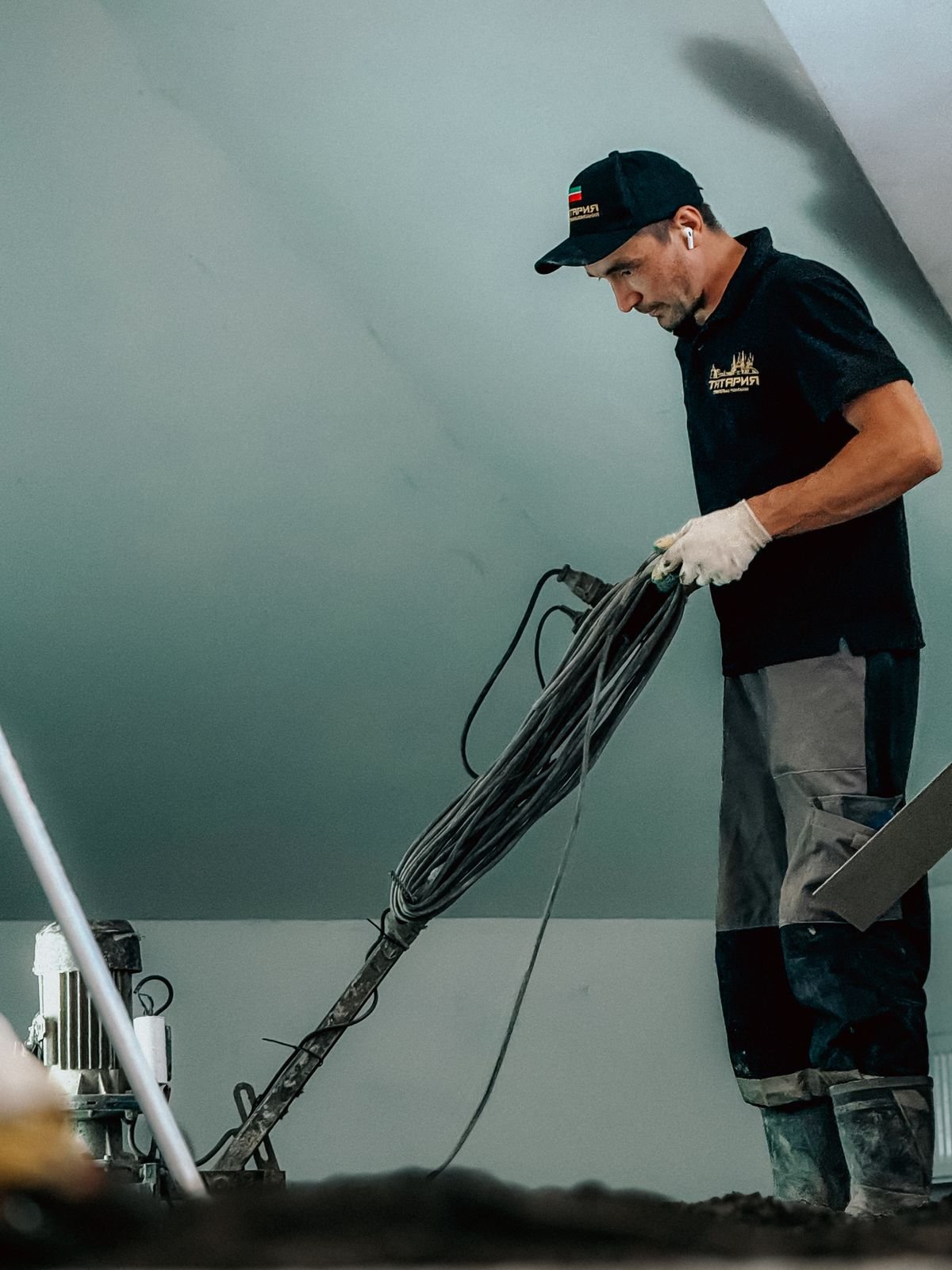 Professional construction worker operating machinery indoors for flooring work