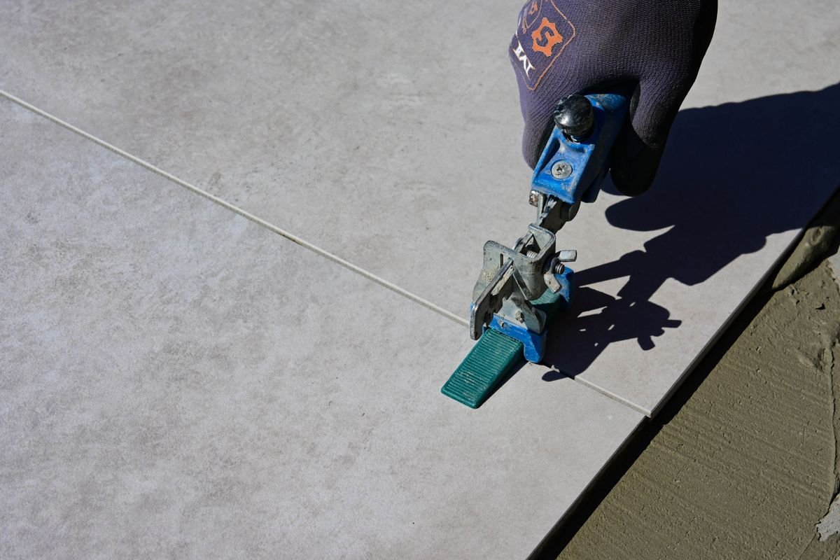 Tile lifting tool placed on a large porcelain floor tile