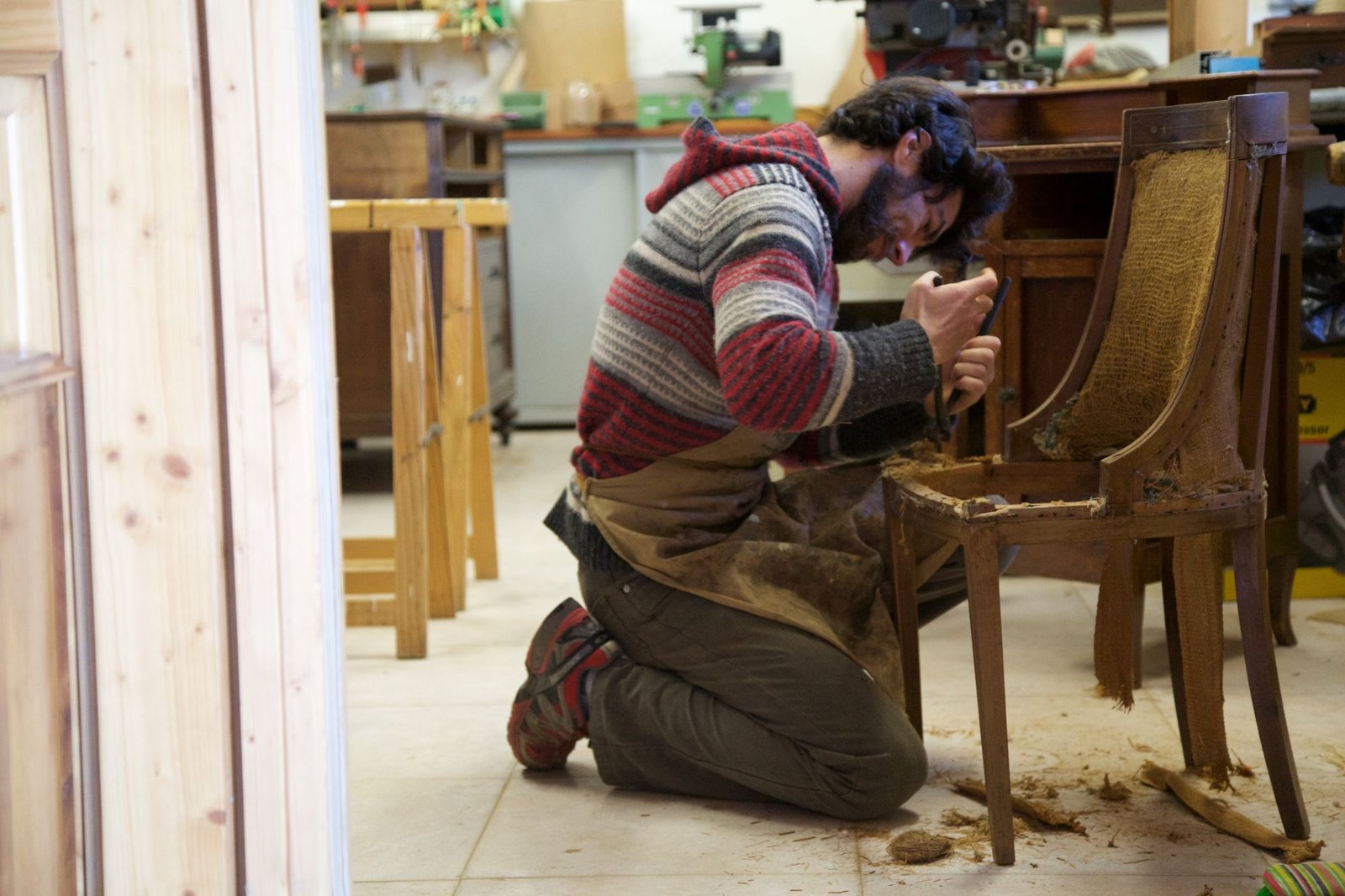 Craftsman restoring an antique wooden chair in a workshop