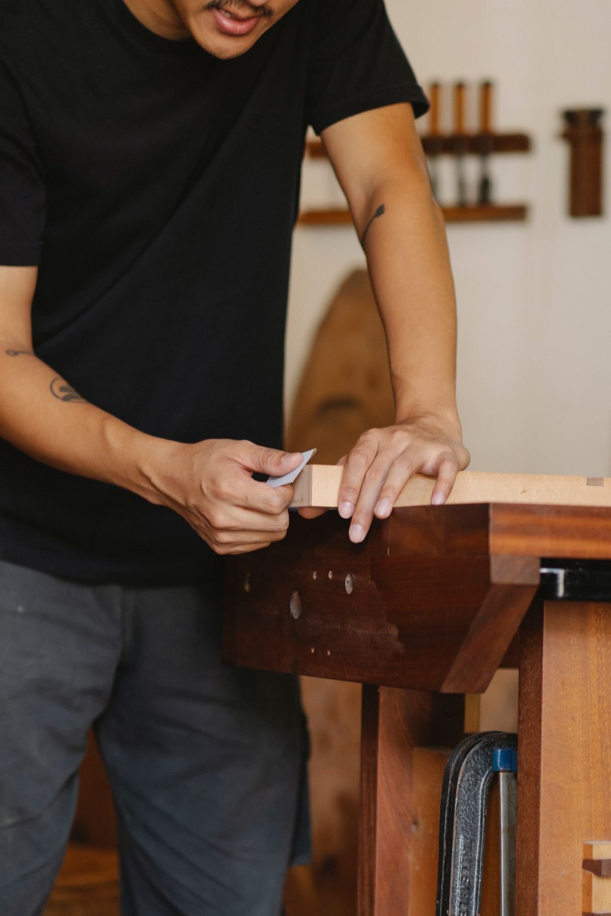 Craftsman polishing a wooden detail in a professional workshop