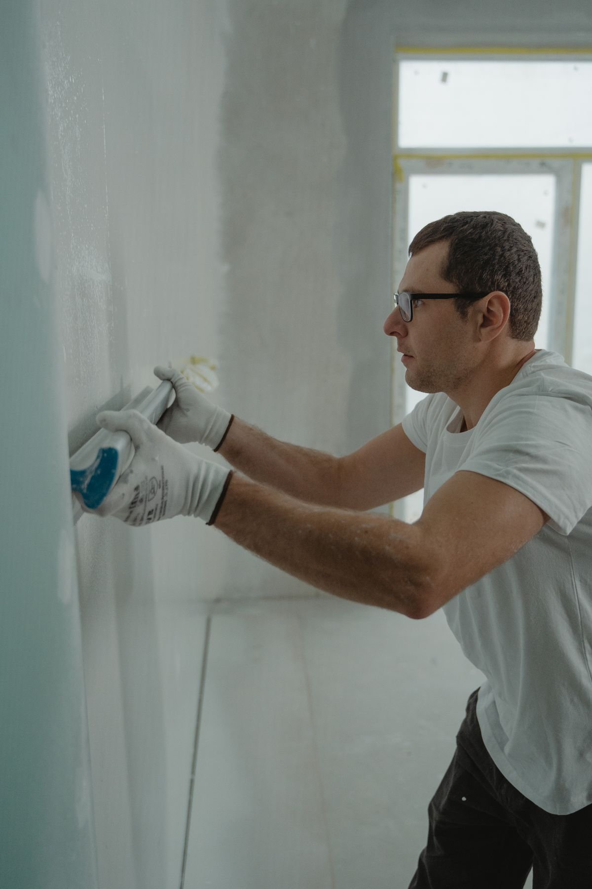 Worker applying drywall compound during renovation