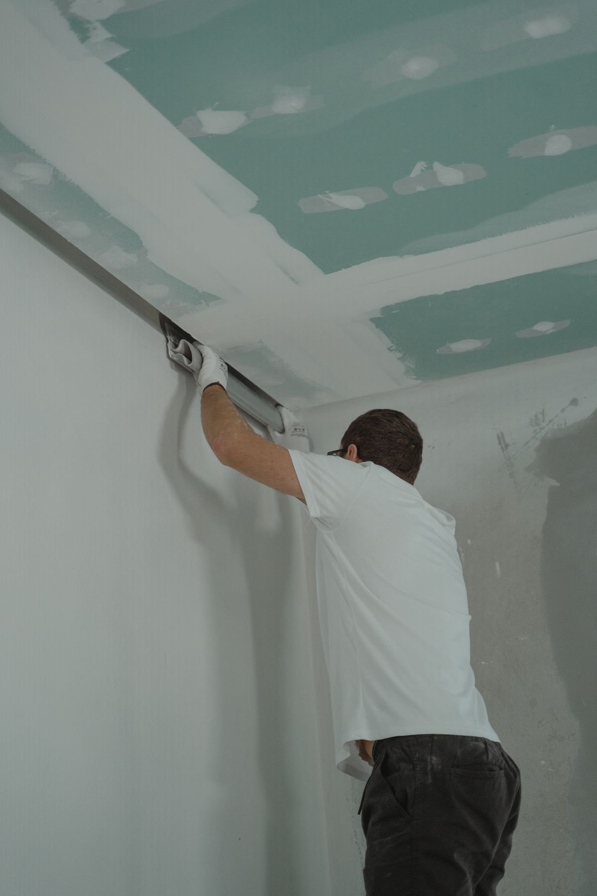 Worker installing drywall during a house renovation