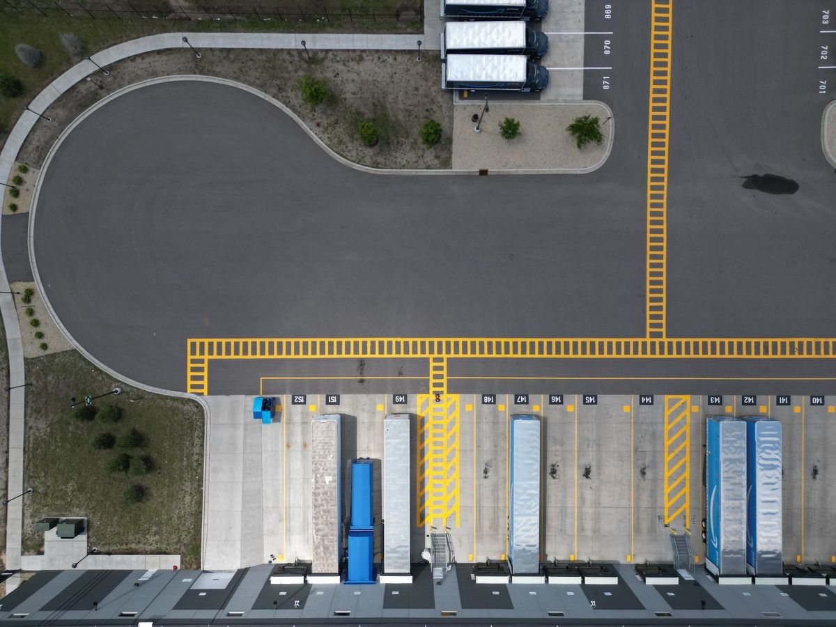 Aerial view of an industrial loading dock area with trucks parked at bays