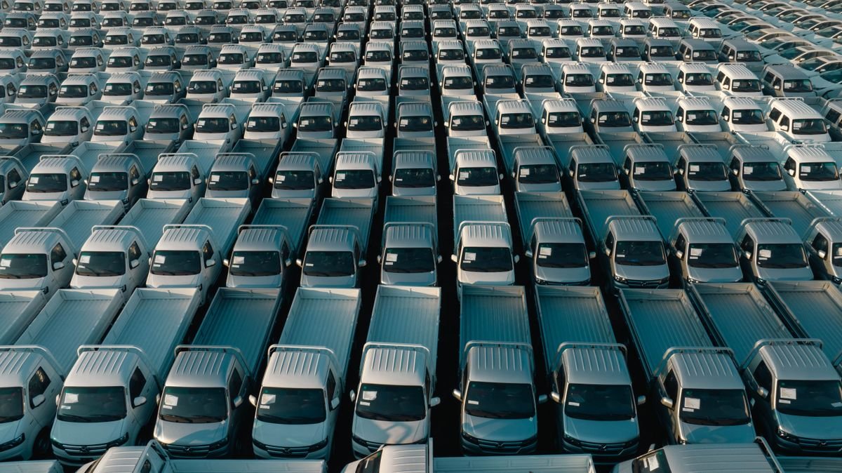 Large paved lot holding rows of parked pickup trucks